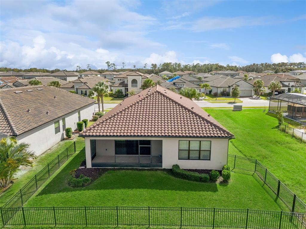 An aerial view of a single-story house with a tiled roof and a screened-in patio — 3964 CARRICK BEND DR, KISSIMMEE, FL