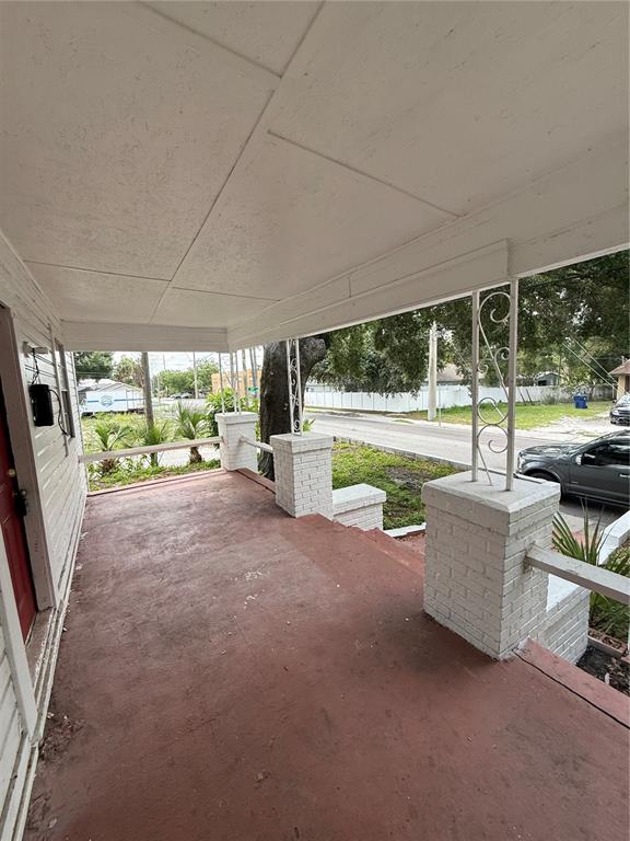 A covered front porch with a painted red floor and white brick support columns — 2712 E COLUMBUS DRIVE, TAMPA, FL