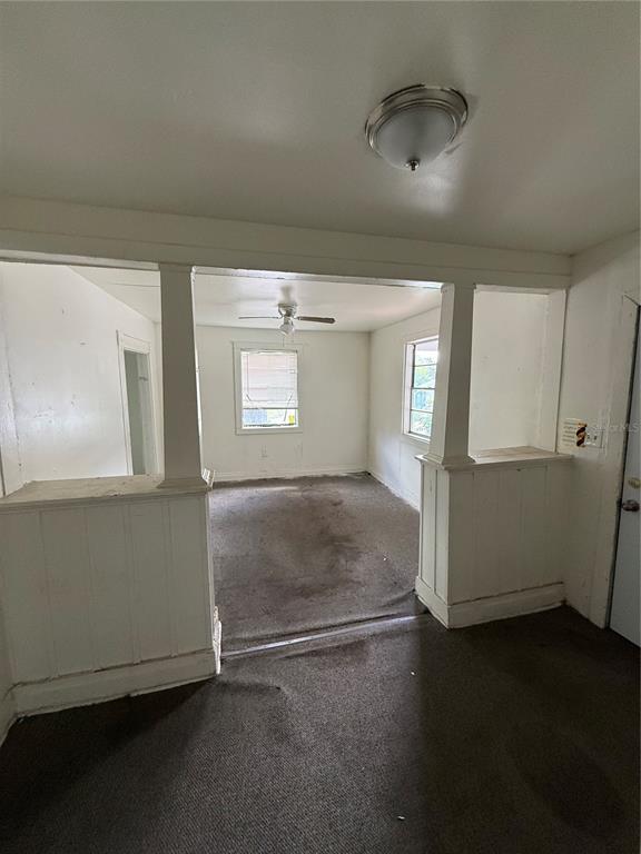 An interior view shows a carpeted living area separated by a half-wall with white pillars — 2712 E COLUMBUS DRIVE, TAMPA, FL