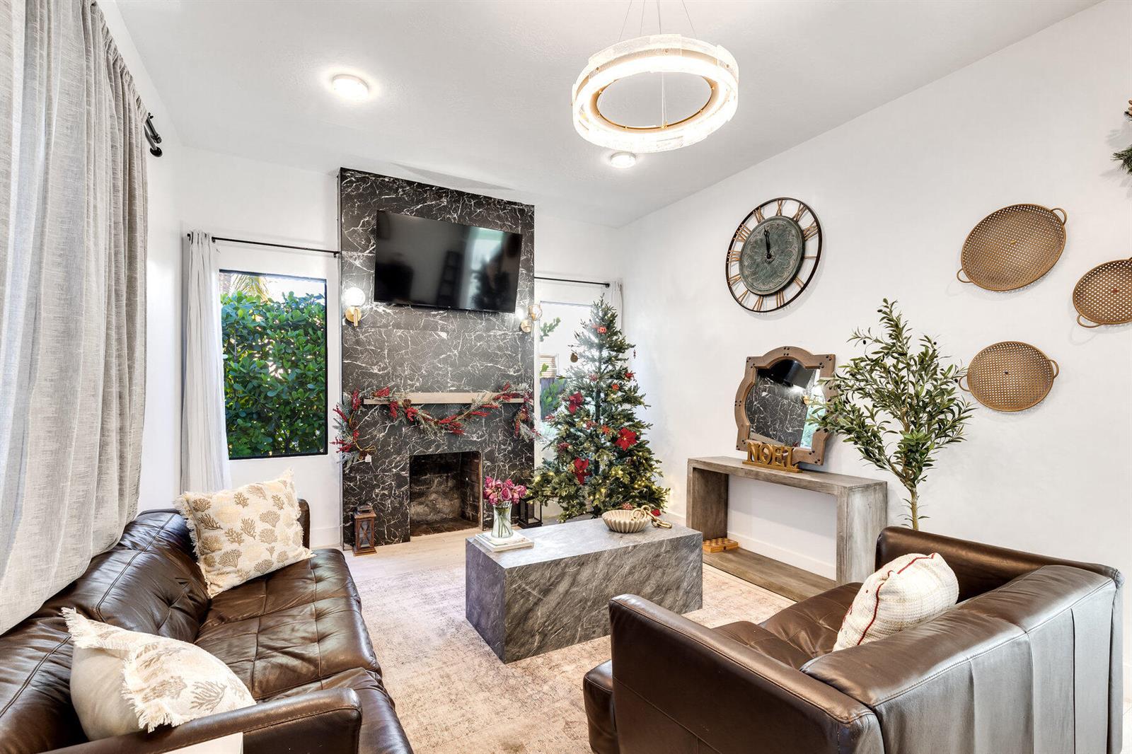 A living room features a black marble fireplace, leather sofas, and a Christmas tree — 726 Lytle Street, West Palm Beach FL 33405, WEST PALM BEACH, FL