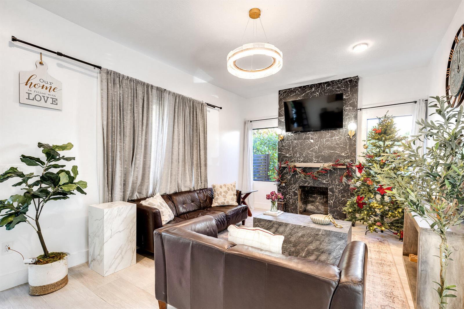 A living room features a dark marble fireplace, brown leather sofas, and a Christmas tree — 726 Lytle Street, West Palm Beach FL 33405, WEST PALM BEACH, FL