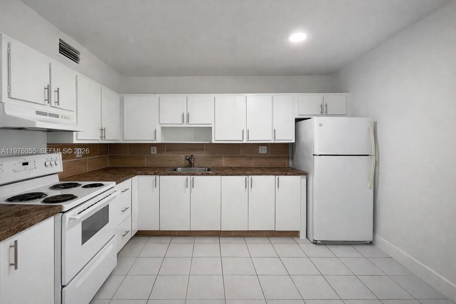 A kitchen features white cabinetry, brown countertops, a white stove, and a white refrigerator — 19255 NE 2nd Ave # 2224, Miami FL 33179, MIAMI, FL