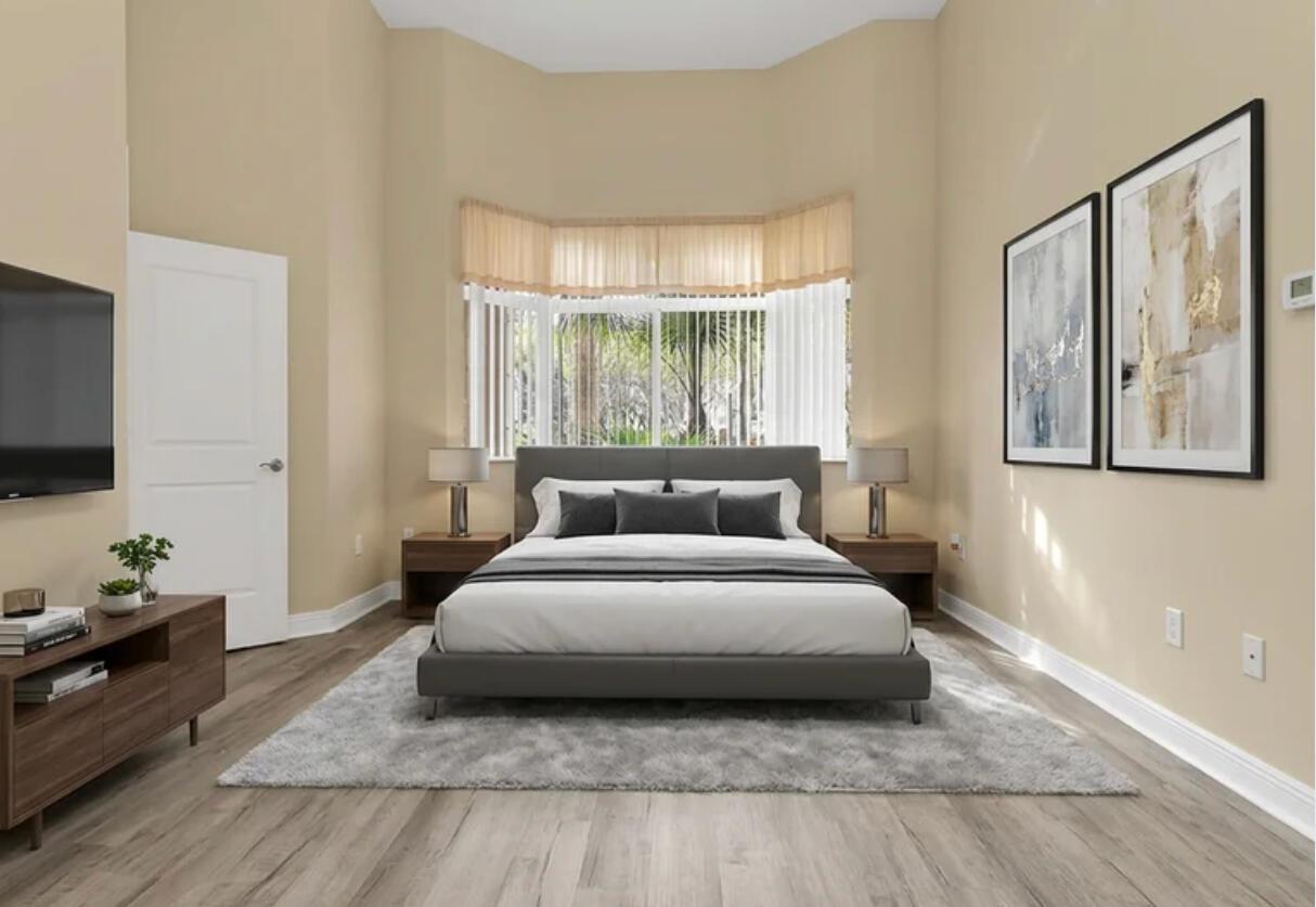 A bedroom features a gray bed, wood nightstands, a gray rug, and a bay window — 16102 Emerald Estates Drive # 108, Weston FL 33331, WESTON, FL