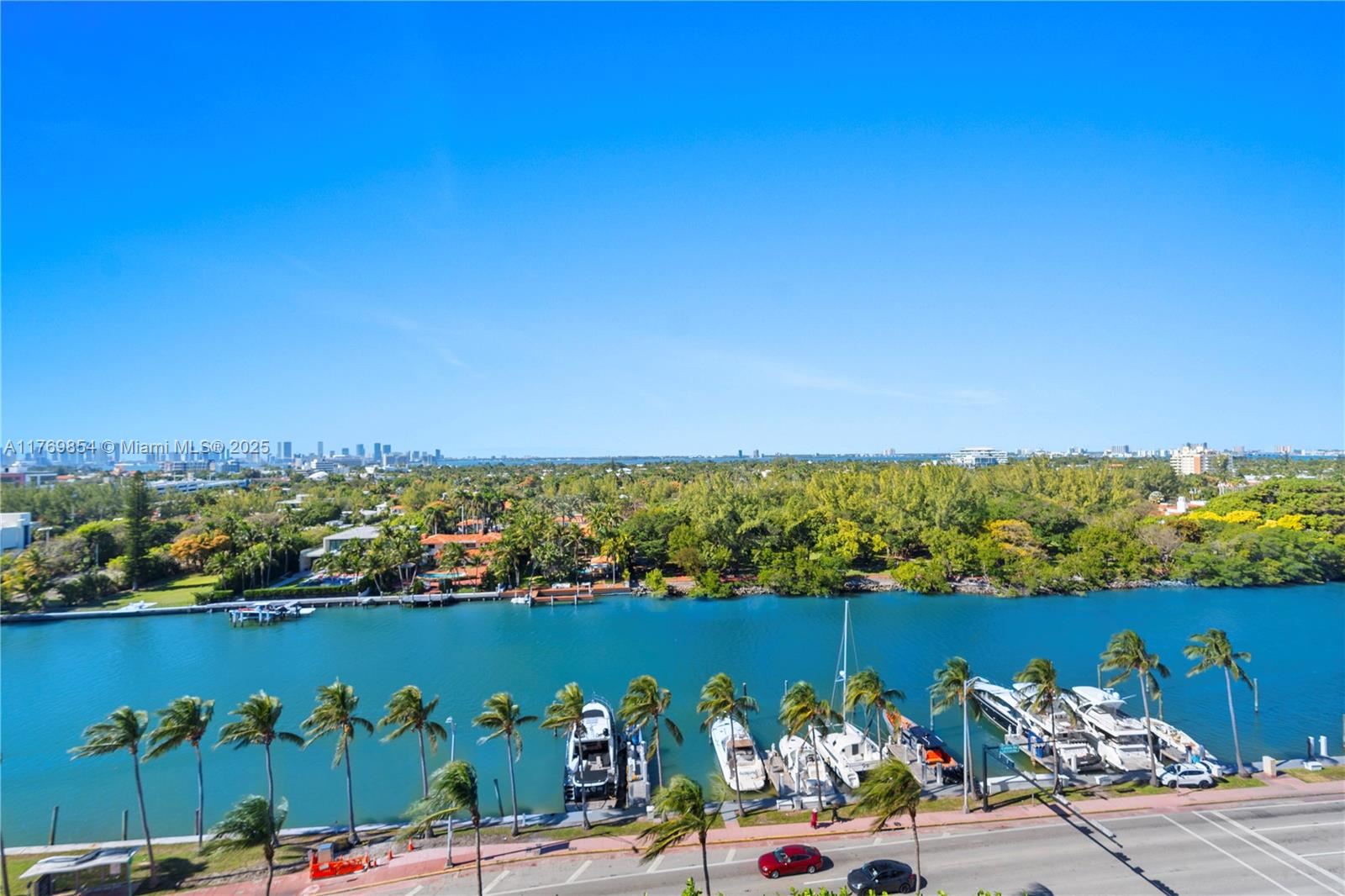 An elevated view shows a canal with docked boats, palm trees, and a road below — 4401 Collins Ave # 1017, Miami Beach FL 33140, MIAMI BEACH, FL