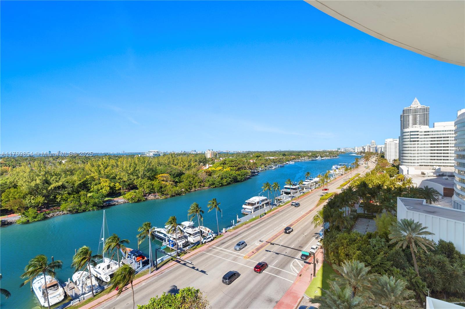 An elevated view shows a coastal road, a waterway with docked boats, and nearby high-rise buildings — 4401 Collins Ave # 1017, Miami Beach FL 33140, MIAMI BEACH, FL