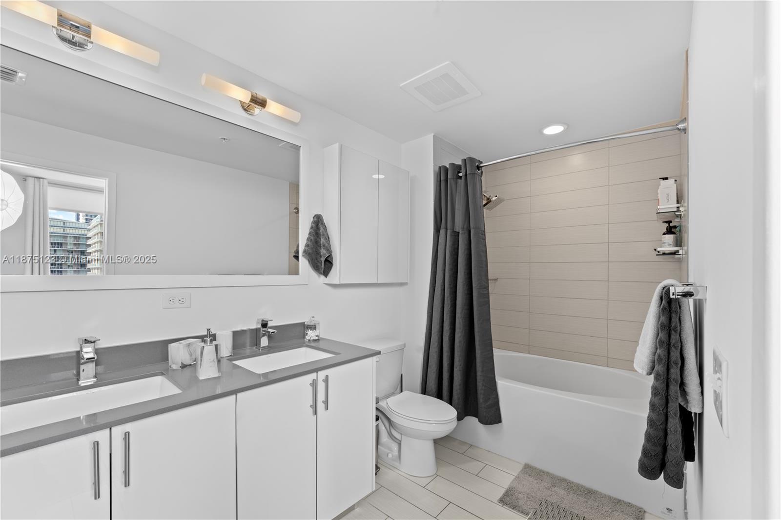 A modern bathroom features a double vanity, a gray countertop, and a shower-tub combination — 999 SW 1st Ave # 3304, Miami FL 33130, MIAMI, FL