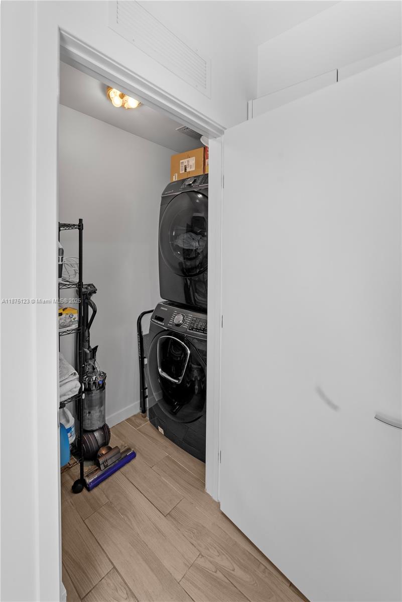 A laundry closet contains a stacked washer and dryer unit and a vacuum cleaner — 999 SW 1st Ave # 3304, Miami FL 33130, MIAMI, FL