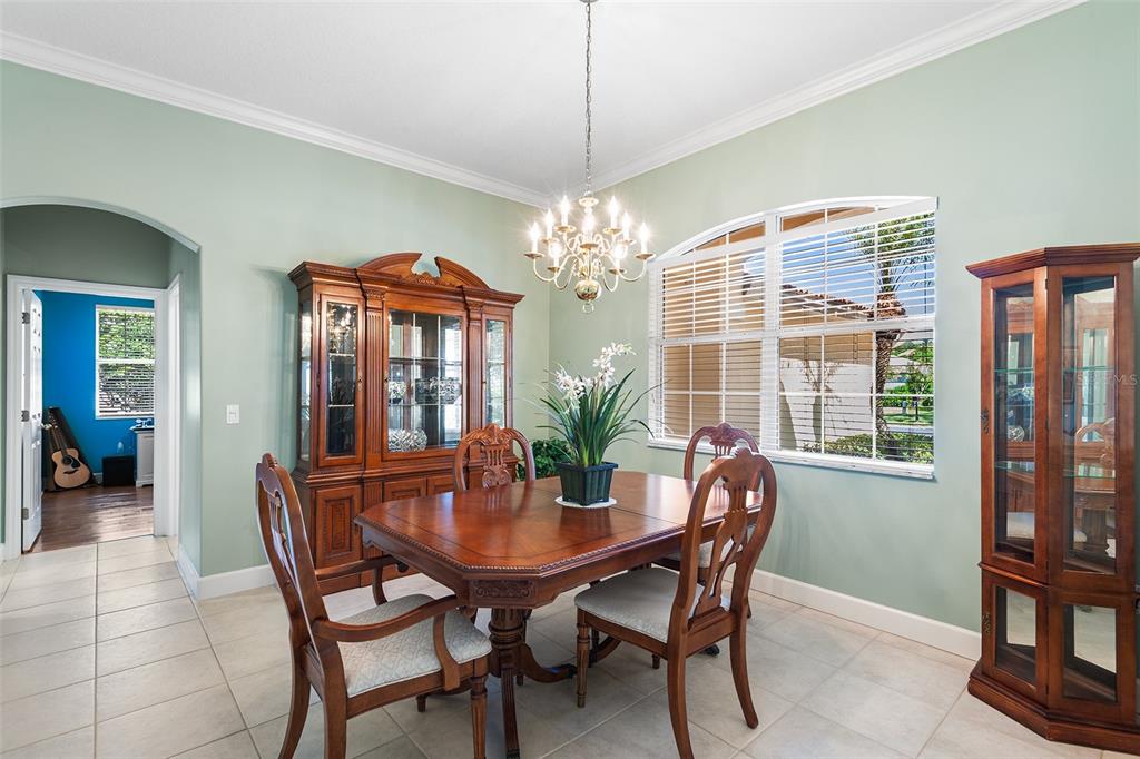 A dining room features a wooden table, chairs, a hutch, and a chandelier — 126 LAKE REGION CIRCLE, WINTER HAVEN, FL