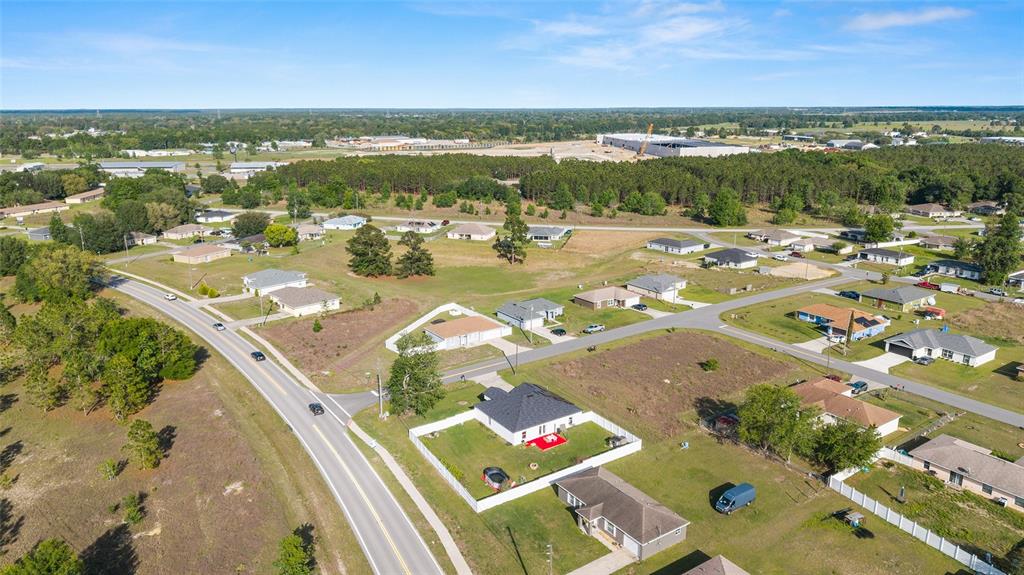 An aerial view shows a residential neighborhood with scattered houses, roads, and surrounding wooded areas — 2 JUNIPER TERRACE, OCALA, FL