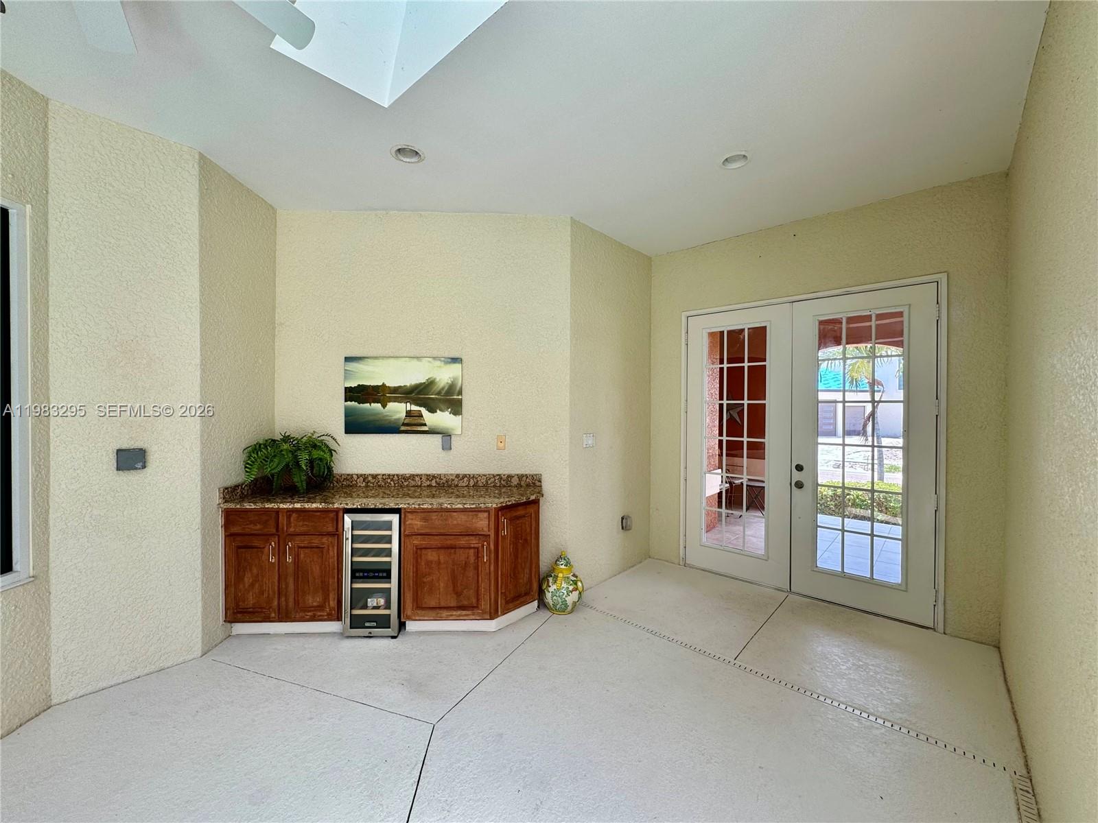A covered patio features a built-in wet bar with granite countertops and a wine cooler — 1740 Ludlow Rd # 1740, Marco Island FL 34145, MARCO ISLAND, FL