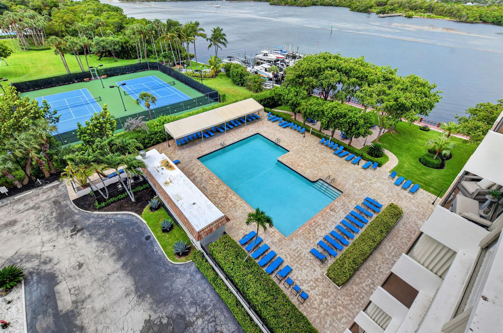An aerial view shows a swimming pool, tennis courts, and a boat dock by water — 2121 N Ocean Boulevard # 805w, Boca Raton FL 33431, BOCA RATON, FL