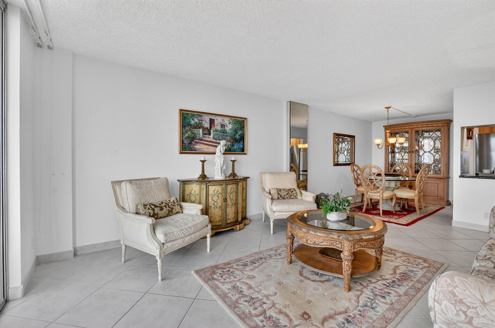 A living and dining room with tile floors, traditional furniture, and a glass-topped coffee table — 2121 N Ocean Boulevard # 805w, Boca Raton FL 33431, BOCA RATON, FL