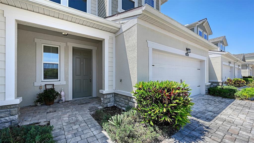 The exterior of a suburban home features a paved driveway, garage, and front entryway — 3693 DIVOT LANE, SARASOTA, FL