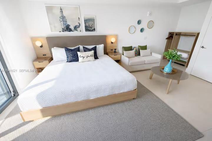 A bedroom features a king bed, a small sofa, a coffee table, and an open closet — 159 NE 6th St # 2606, Miami FL 33132, MIAMI, FL