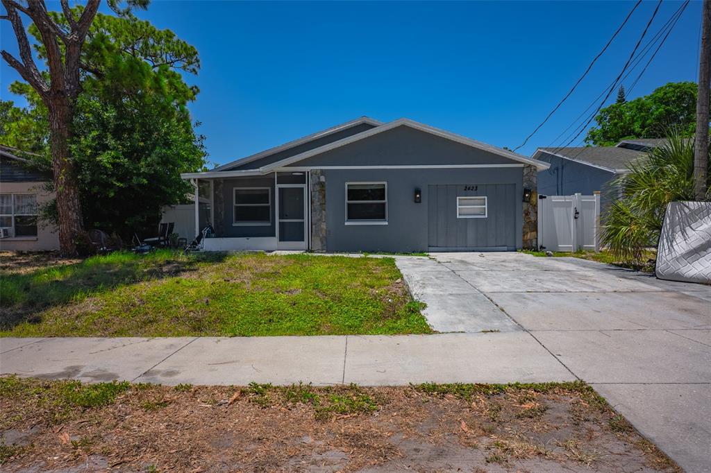 A gray single-story house with a concrete driveway and a front lawn — 2423 23RD STREET, SARASOTA, FL