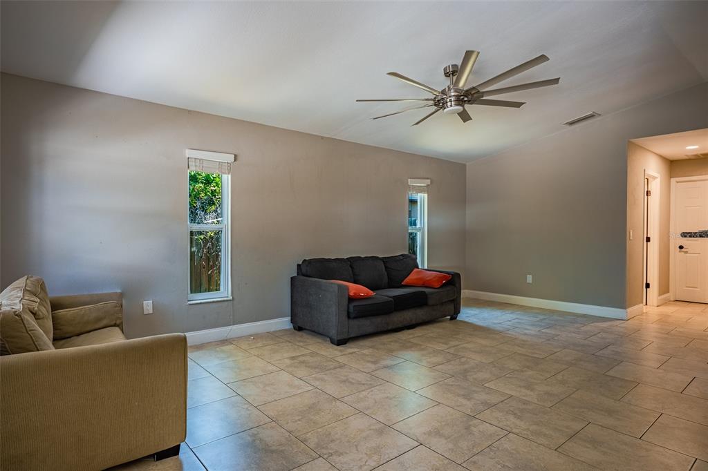 A living room features beige walls, tile flooring, two sofas, and a ceiling fan — 2423 23RD STREET, SARASOTA, FL