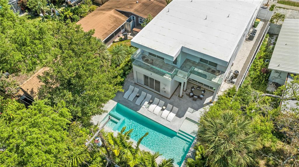 An aerial view of a modern house with a swimming pool and patio lounge area — 2327 HILLVIEW STREET, SARASOTA, FL