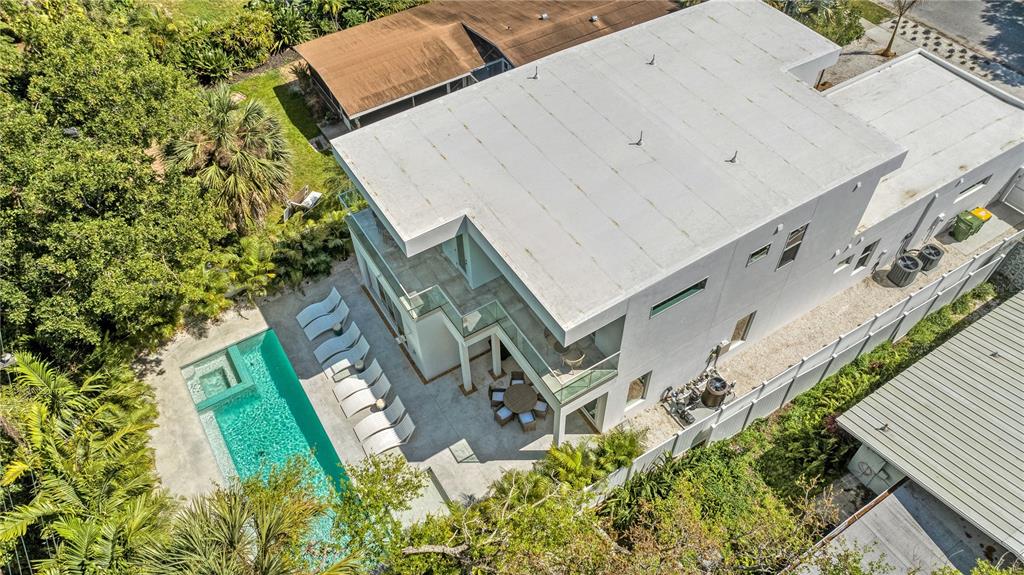An aerial view shows a modern multi-story house with a swimming pool and patio area — 2327 HILLVIEW STREET, SARASOTA, FL