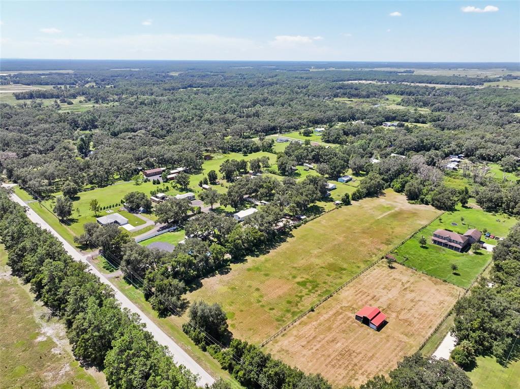 A wide, grassy field is bordered by a line of trees under a cloudy sky — BELLAMY BROTHERS BOULEVARD, DADE CITY, FL