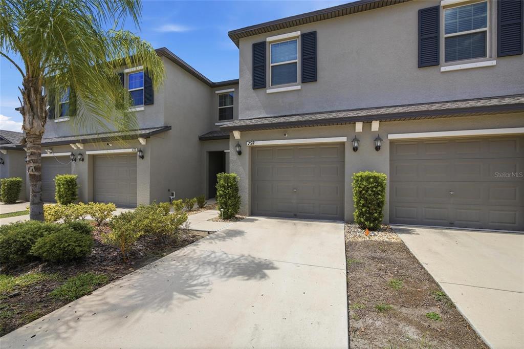 A view of the exterior of two attached townhomes with garages and concrete driveways — 724 ROYAL EMPRESS DRIVE, RUSKIN, FL