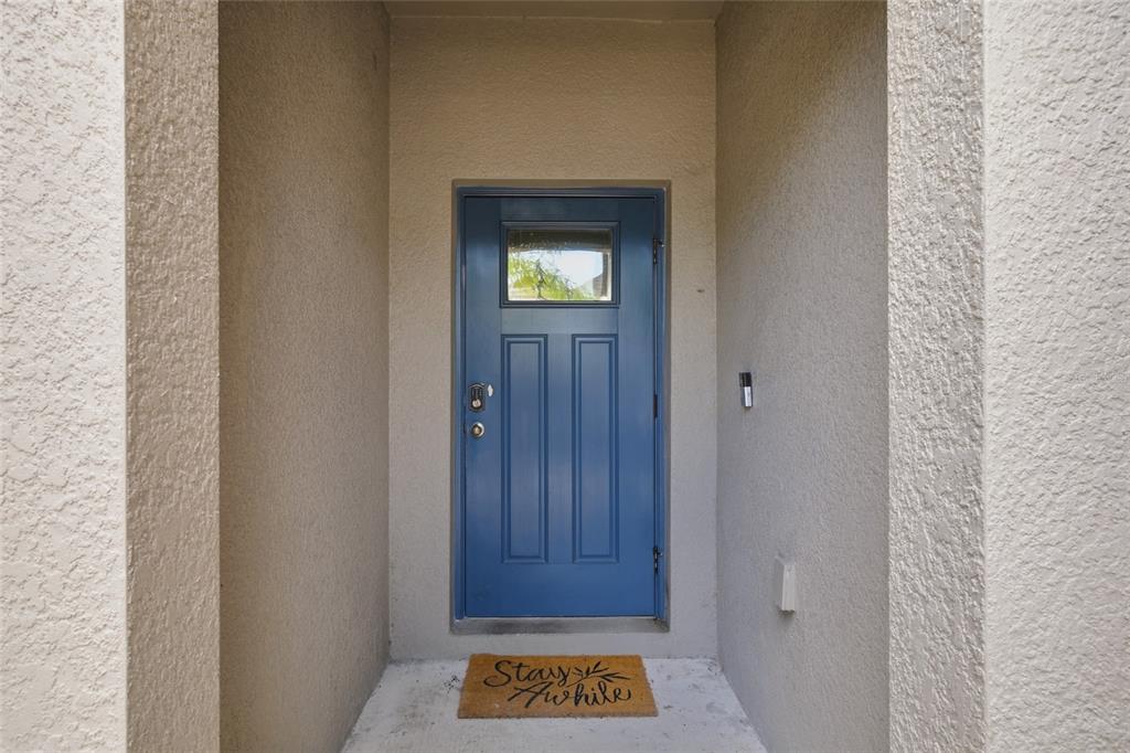 A blue front door with a small window sits in a recessed entryway — 724 ROYAL EMPRESS DRIVE, RUSKIN, FL