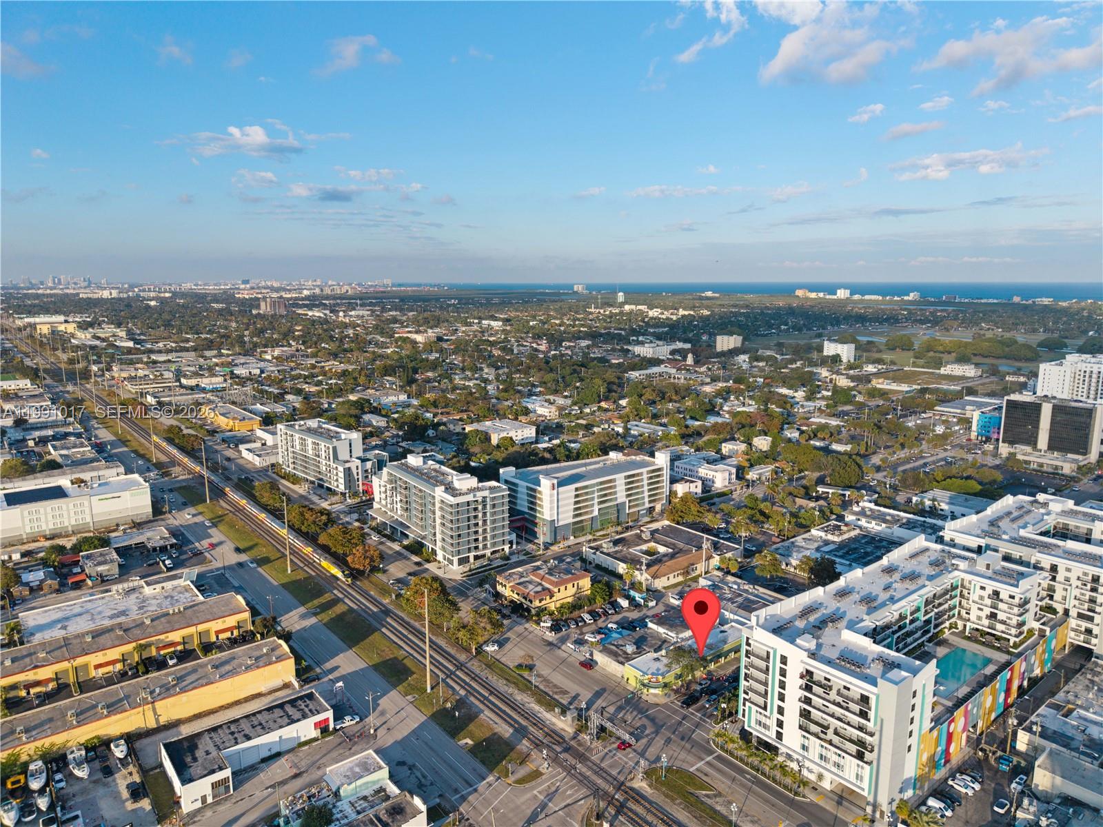 An aerial view shows a city street with railroad tracks, apartment buildings, and a red pin — 2041 Tyler, Hollywood FL 33020, HOLLYWOOD, FL