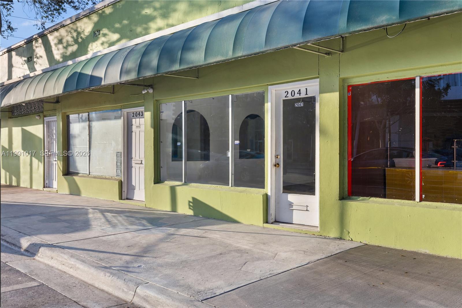 A lime green commercial building exterior features two white doors and large glass display windows — 2041 Tyler, Hollywood FL 33020, HOLLYWOOD, FL