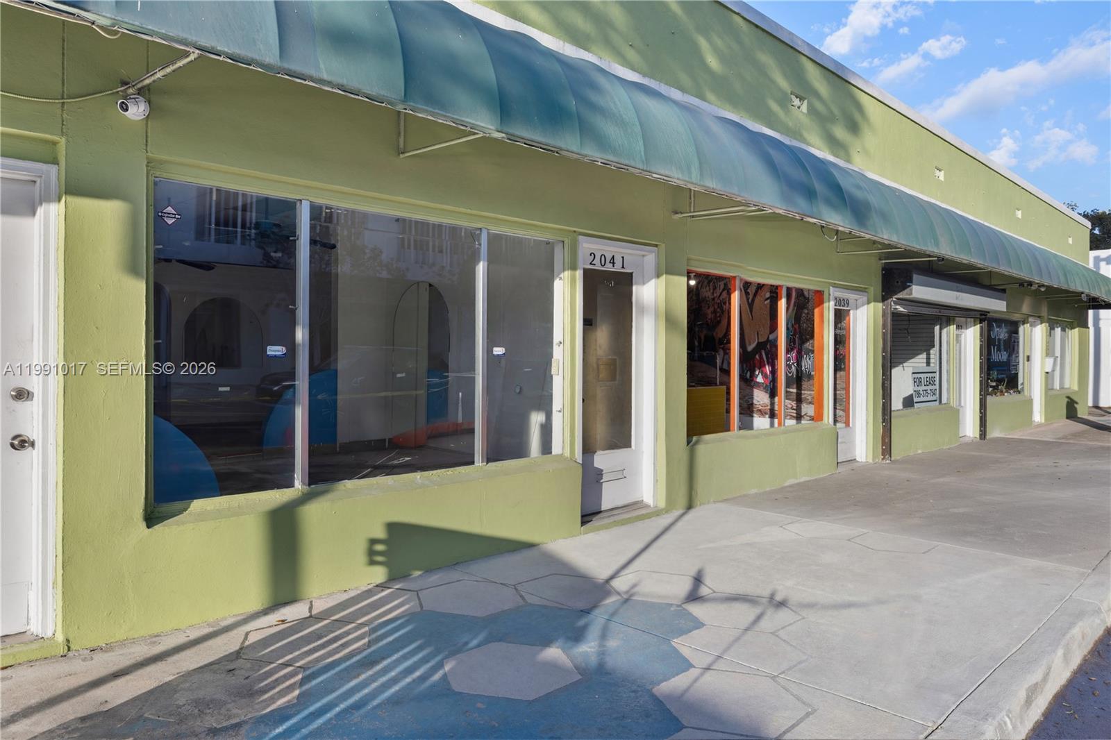 A green commercial building exterior features large storefront windows and a metal awning — 2041 Tyler, Hollywood FL 33020, HOLLYWOOD, FL