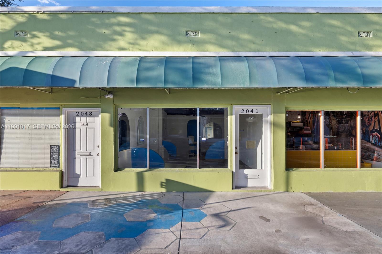 The exterior of a lime green commercial building features two white doors and large windows — 2041 Tyler, Hollywood FL 33020, HOLLYWOOD, FL