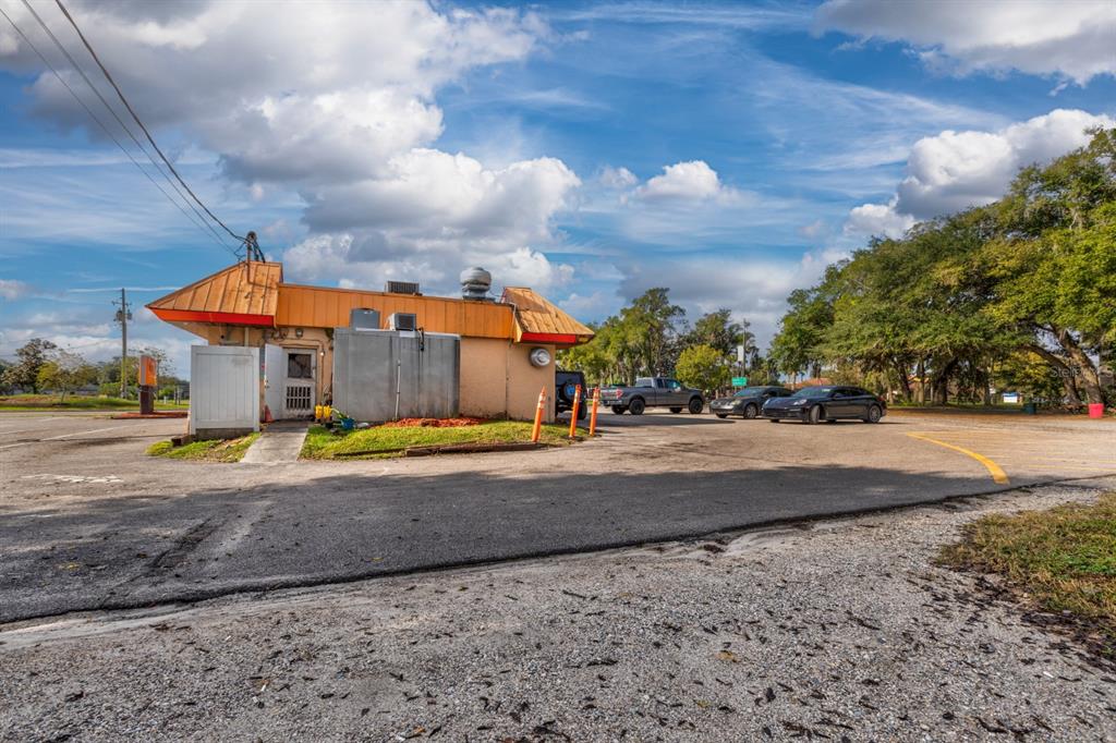 The exterior of a commercial building with a metal roof and a paved parking lot — 299 E BROAD STREET, GROVELAND, FL