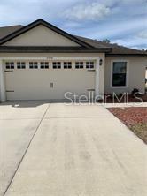 A beige single-story house features a two-car garage and a concrete driveway — 5578 MAGGIORE BOULEVARD, LAKELAND, FL