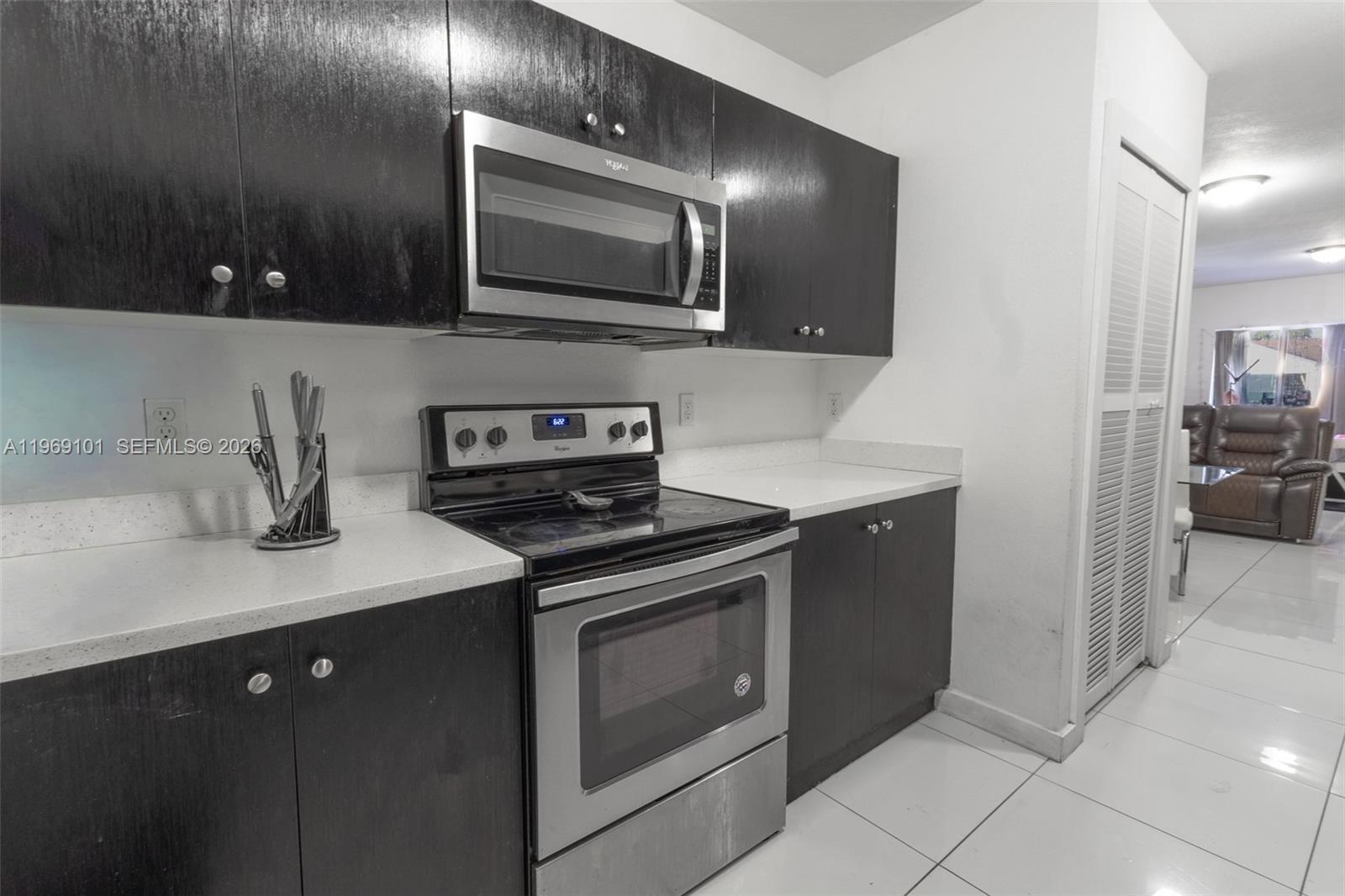A kitchen features dark wood cabinets, stainless steel appliances, and white countertops — 1998 NW 47th St, Miami FL 33142, MIAMI, FL