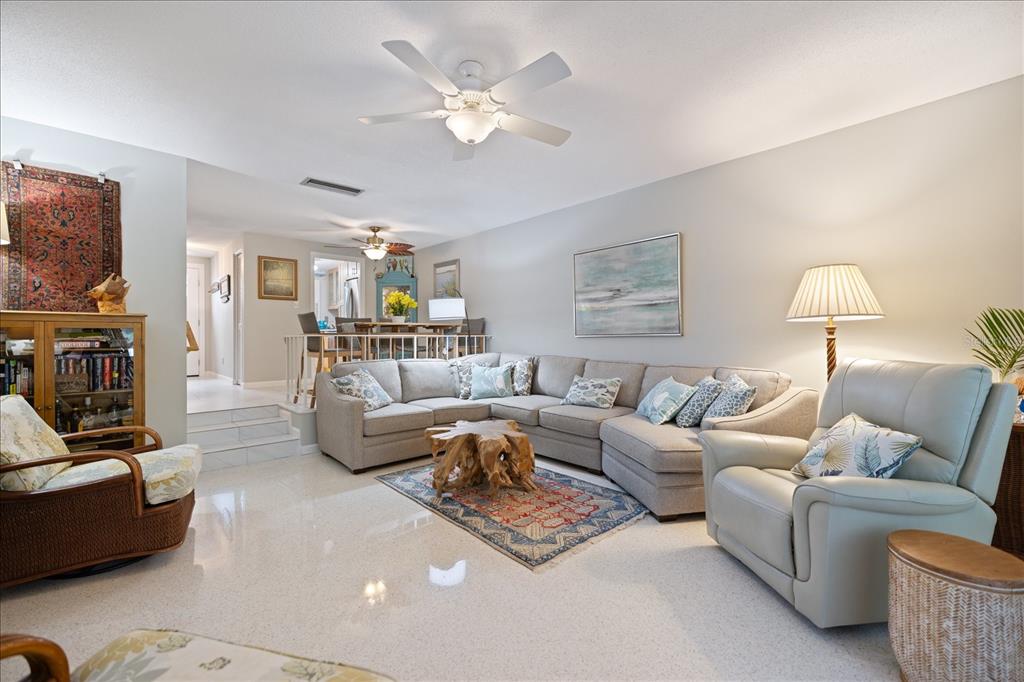 A living room features a large sectional sofa, a light-colored armchair, and a ceiling fan — 707 W VENICE AVENUE UNIT 707B, VENICE, FL