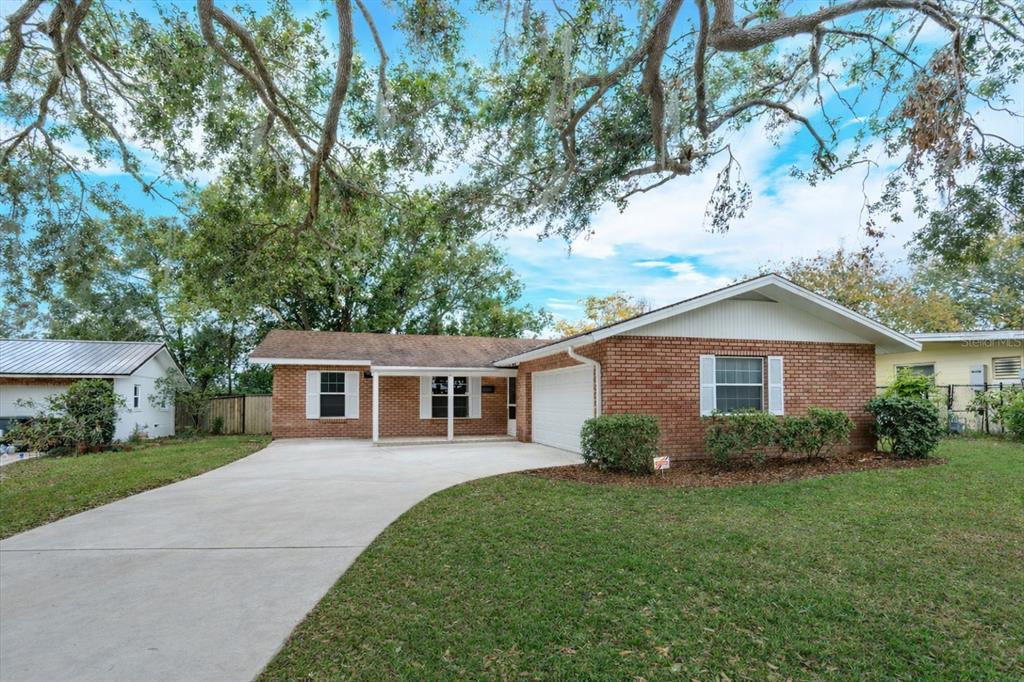 A single-story brick house with a concrete driveway and a large tree in the yard — 530 MAR NAN MAR PLACE, CLERMONT, FL
