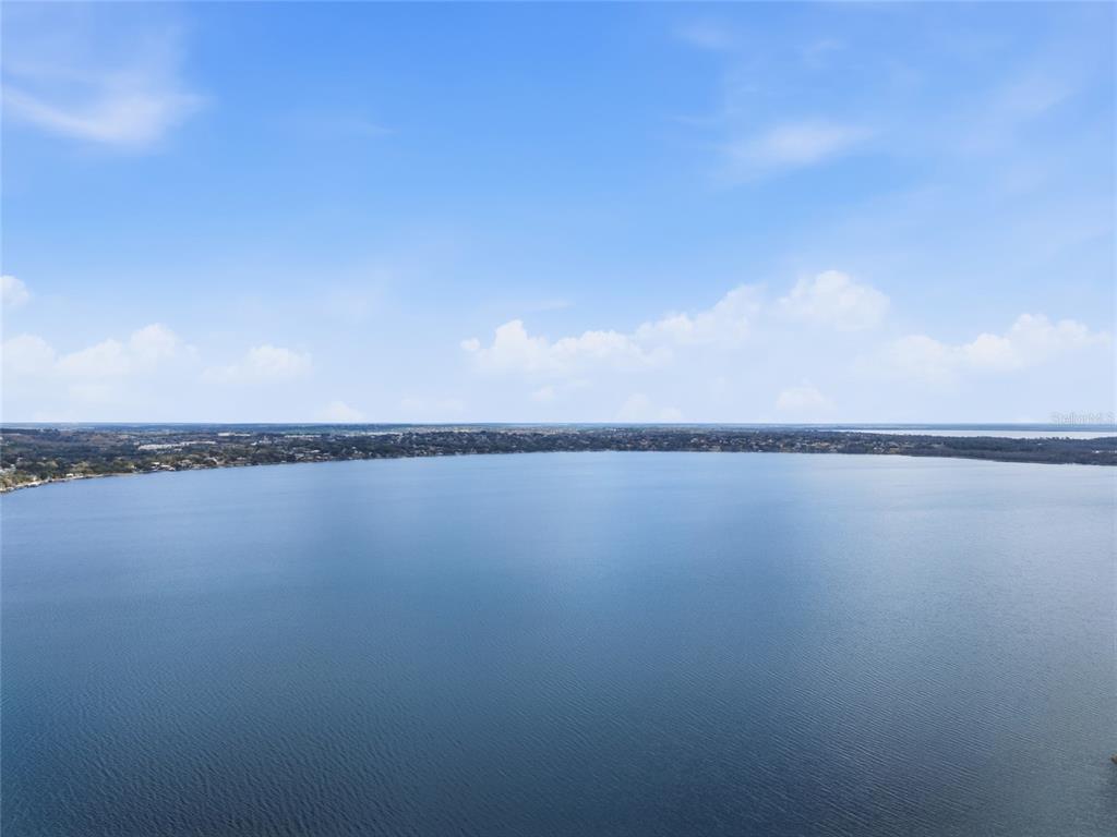 An aerial view of a large, calm lake under a blue sky with scattered clouds — 530 MAR NAN MAR PLACE, CLERMONT, FL