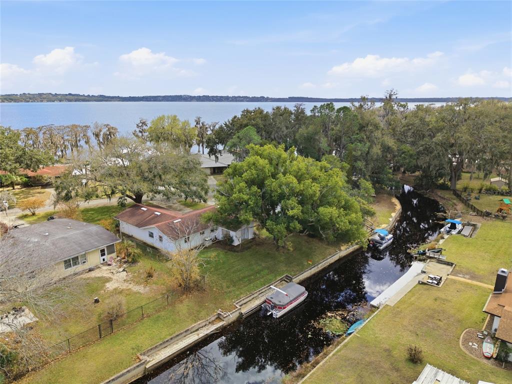 An aerial view shows a house with a canal, boat, and large lake in background — 530 MAR NAN MAR PLACE, CLERMONT, FL