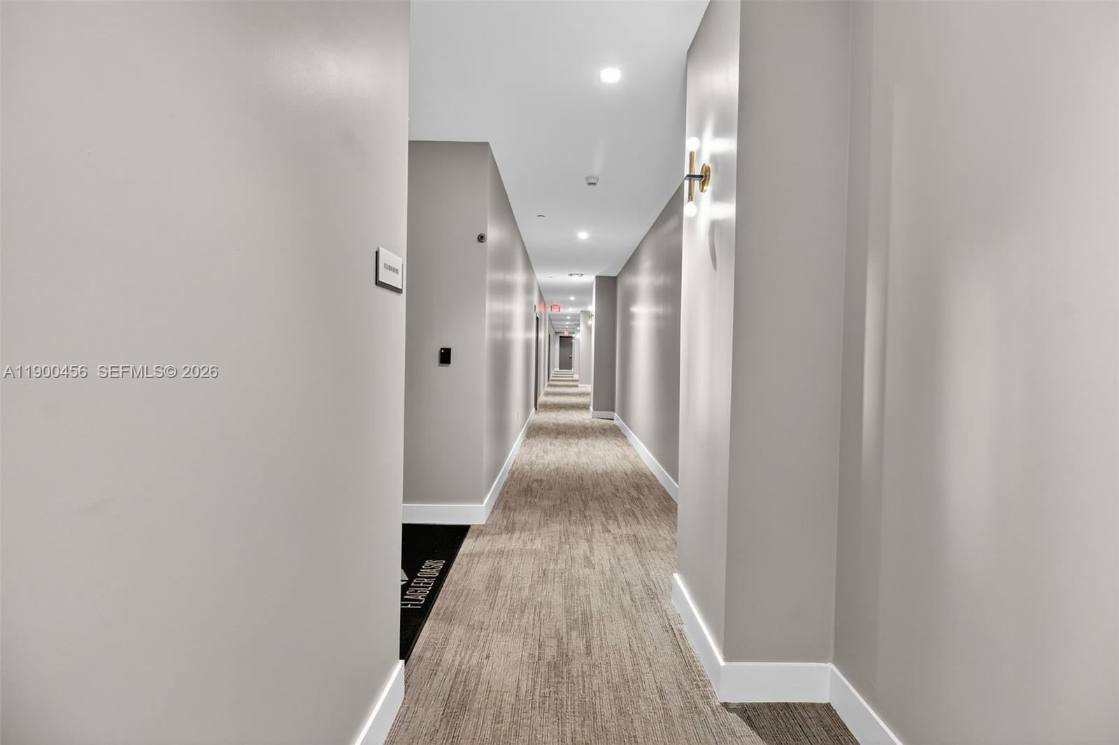A long, narrow hallway features gray walls, recessed lighting, and a neutral-toned carpeted floor — 1110 NW 1 ST # 705, Miami FL 33128, MIAMI, FL