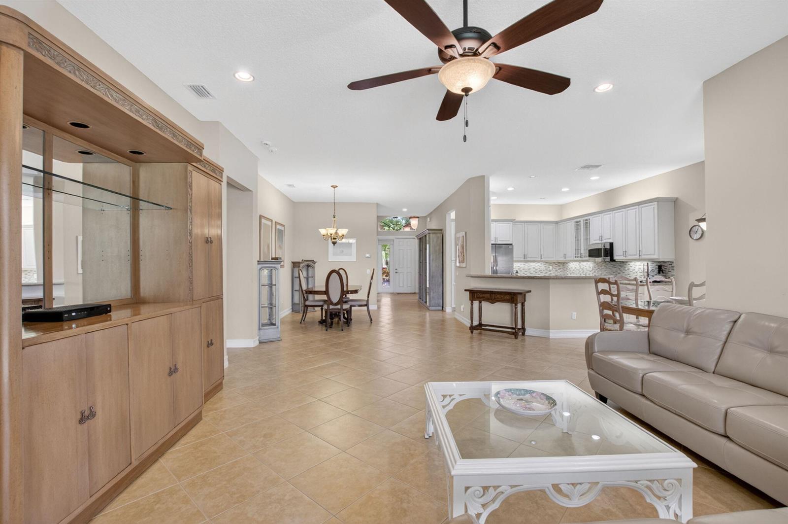 An open-concept living and dining area features tile flooring, a ceiling fan, and a kitchen — 9052 Greenstone Ridge Way, Boynton Beach FL 33473, BOYNTON BEACH, FL