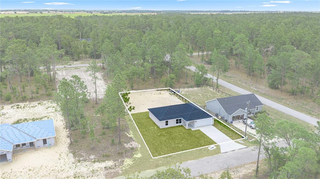 An aerial view shows a new single-story house with a white exterior and dark roof — 24013 NW TAMARIND LANE, DUNNELLON, FL