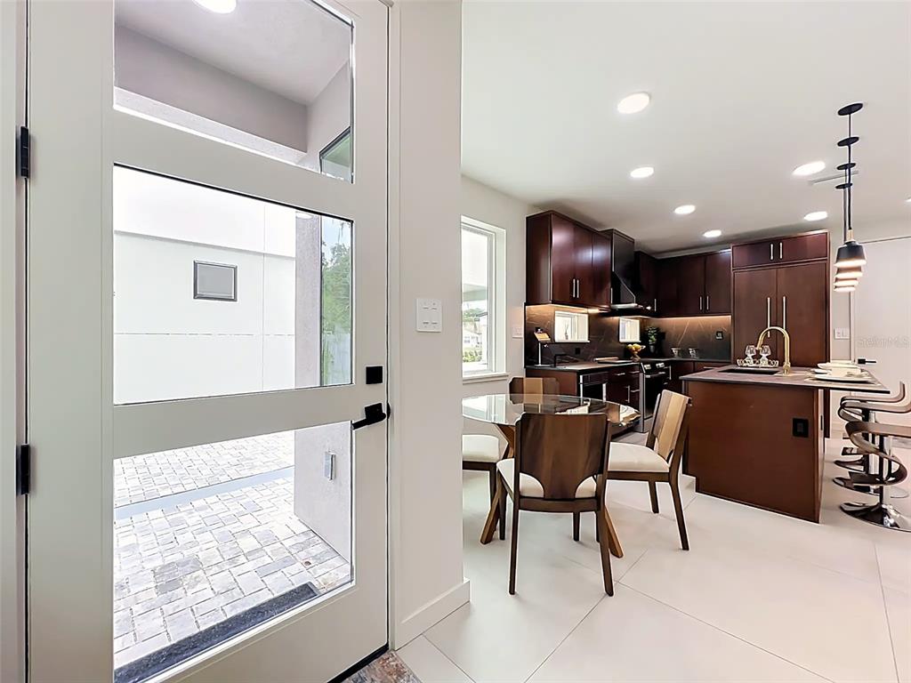 A modern kitchen features dark wood cabinets, gold hardware, and black stone countertops with gold veining — 102 W PRINCETON STREET, ORLANDO, FL