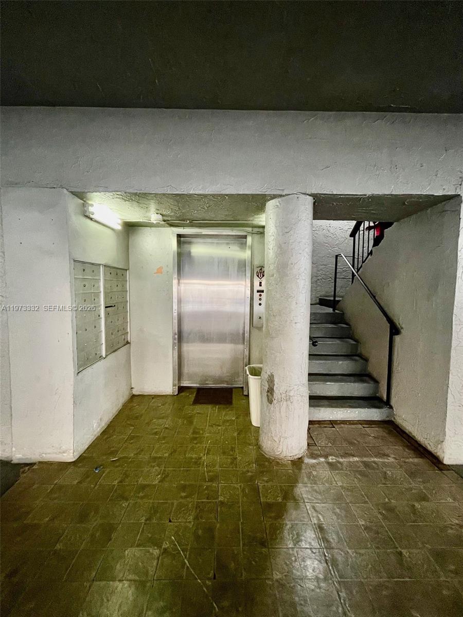 An indoor building lobby features a metal elevator, a staircase, and wall-mounted mailboxes — 1035 W 77th St # 412, Hialeah FL 33014, HIALEAH, FL