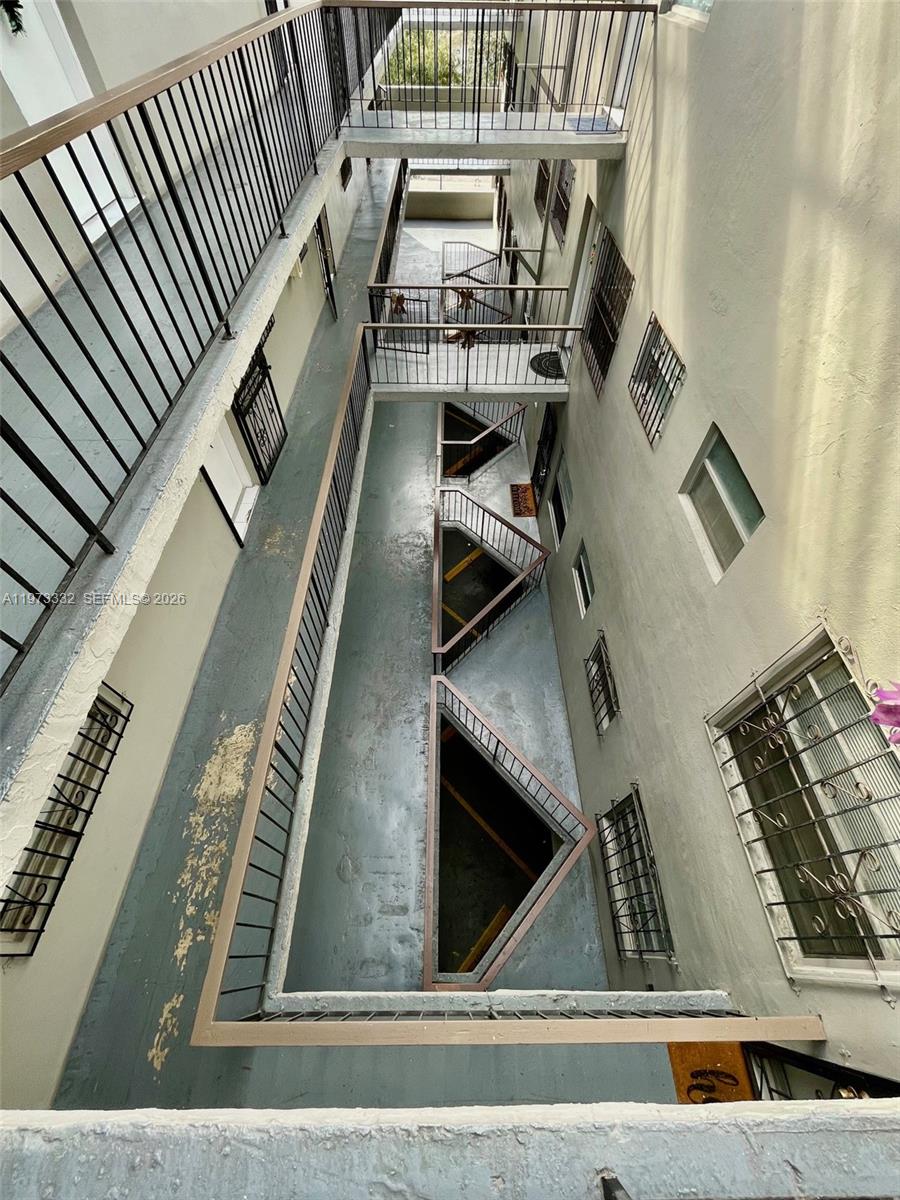 An elevated view looking down into an open-air apartment complex courtyard with metal walkways — 1035 W 77th St # 412, Hialeah FL 33014, HIALEAH, FL