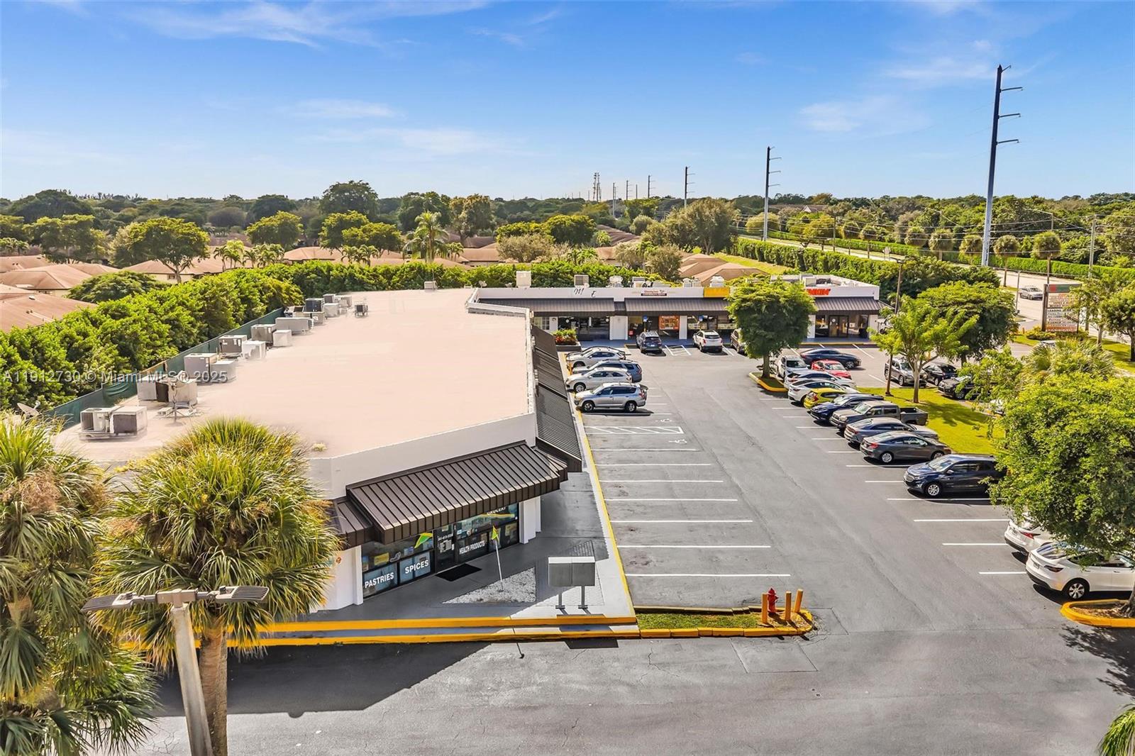 An aerial view shows a commercial strip mall with a parking lot and surrounding trees — 10114 S Military Trl, Boynton Beach FL 33436, BOYNTON BEACH, FL