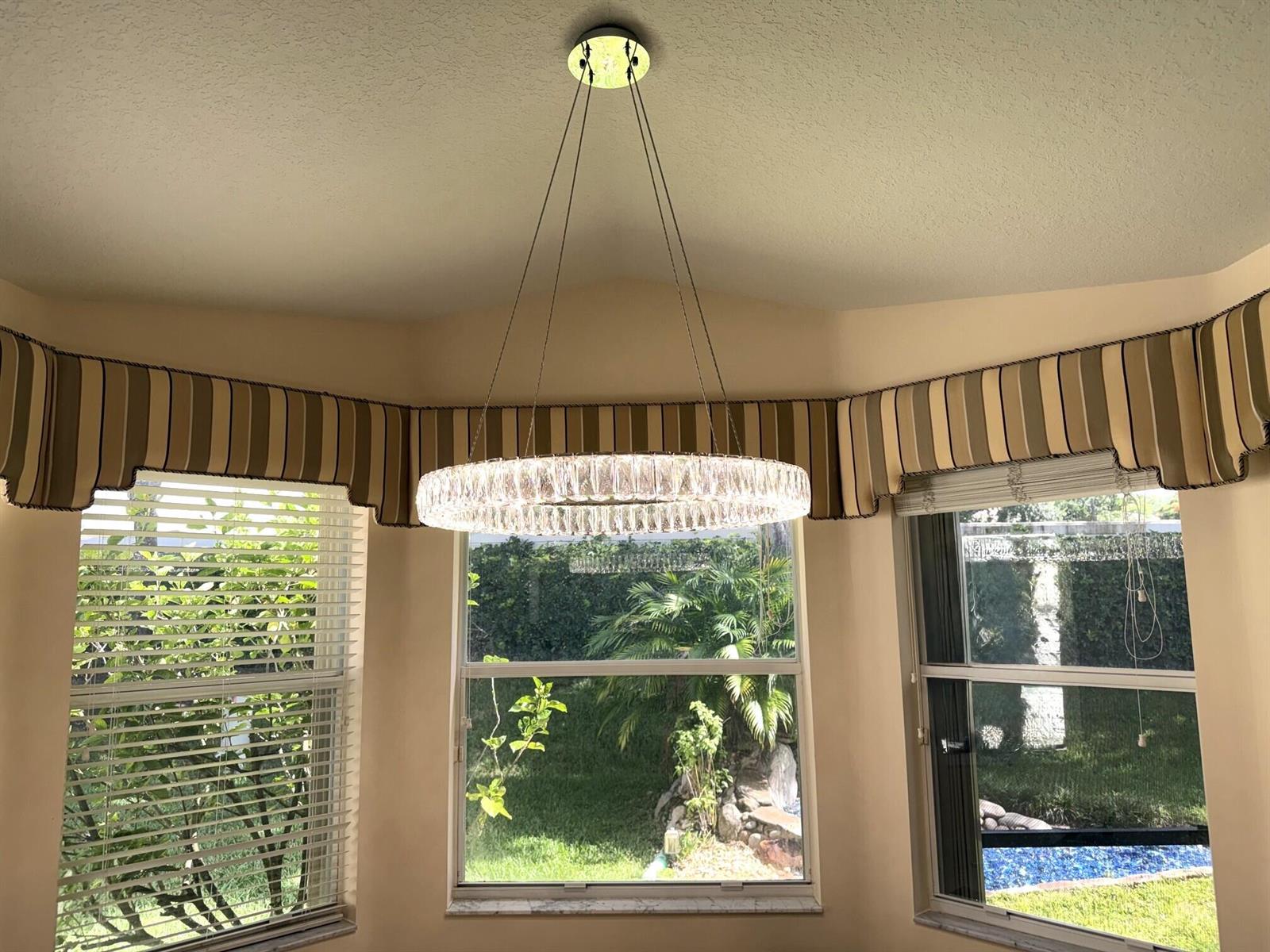 A circular crystal chandelier hangs in a breakfast nook with striped valances and bay windows — 8135 Playa Del Sur Boulevard, Lake Worth FL 33467, LAKE WORTH, FL
