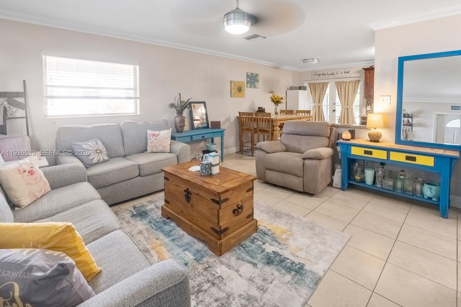 A living room features light gray sofas, a wooden trunk coffee table, and blue furniture — 7002 NW 95th Ave, Tamarac FL 33321, TAMARAC, FL