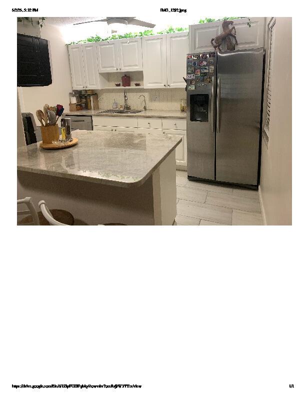 A kitchen features white cabinets, a stone-topped island, stainless steel appliances, and light-colored tile flooring — 1914 Palmland Drive # C, Boynton Beach FL 33436, BOYNTON BEACH, FL