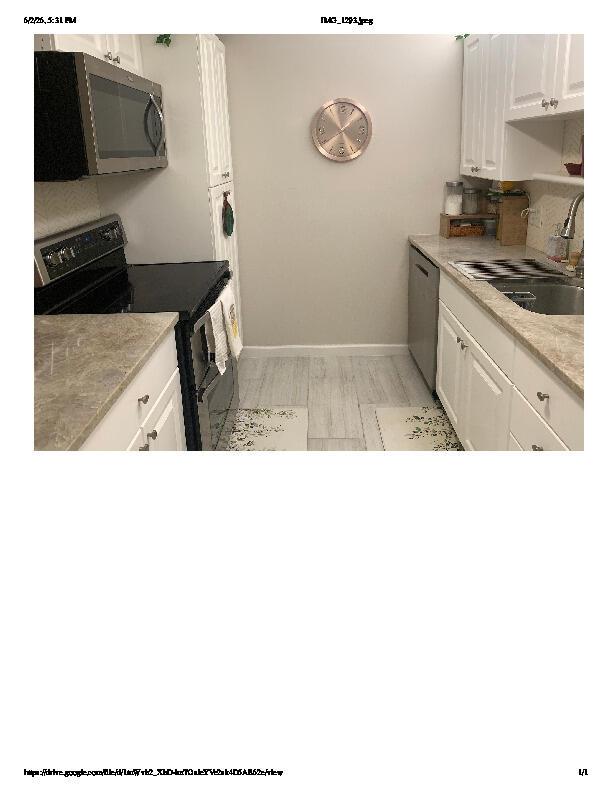 A galley kitchen features white cabinets, stainless steel appliances, and light-colored countertops — 1914 Palmland Drive # C, Boynton Beach FL 33436, BOYNTON BEACH, FL