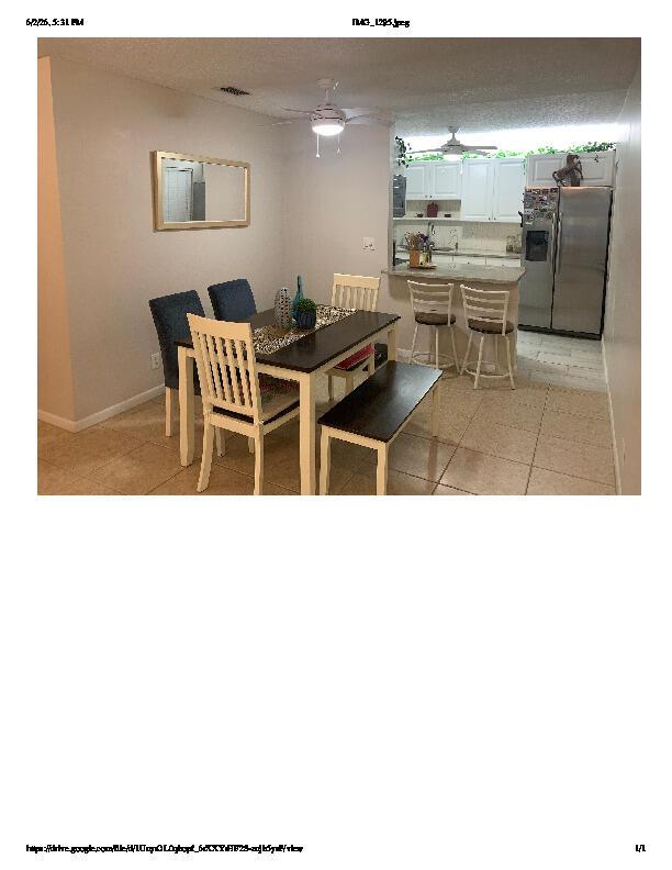 A dining area with a table and chairs sits adjacent to an open kitchen counter — 1914 Palmland Drive # C, Boynton Beach FL 33436, BOYNTON BEACH, FL