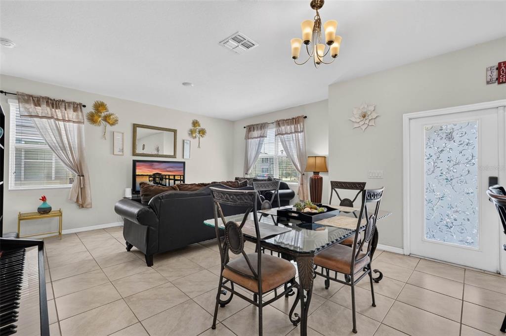 A dining area with a glass table and chairs sits adjacent to a living room — 1655 PHAM DRIVE, PORT ORANGE, FL
