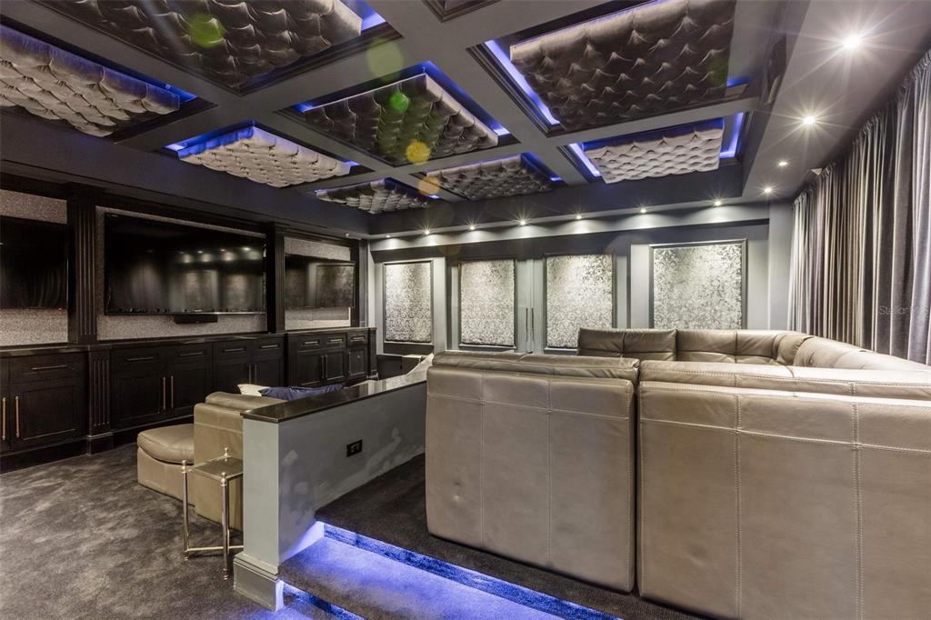 A home theater features tiered leather seating, tufted ceiling panels, and blue accent lighting — 500 PLANTATION DRIVE UNIT PH-3403, DORADO, PR